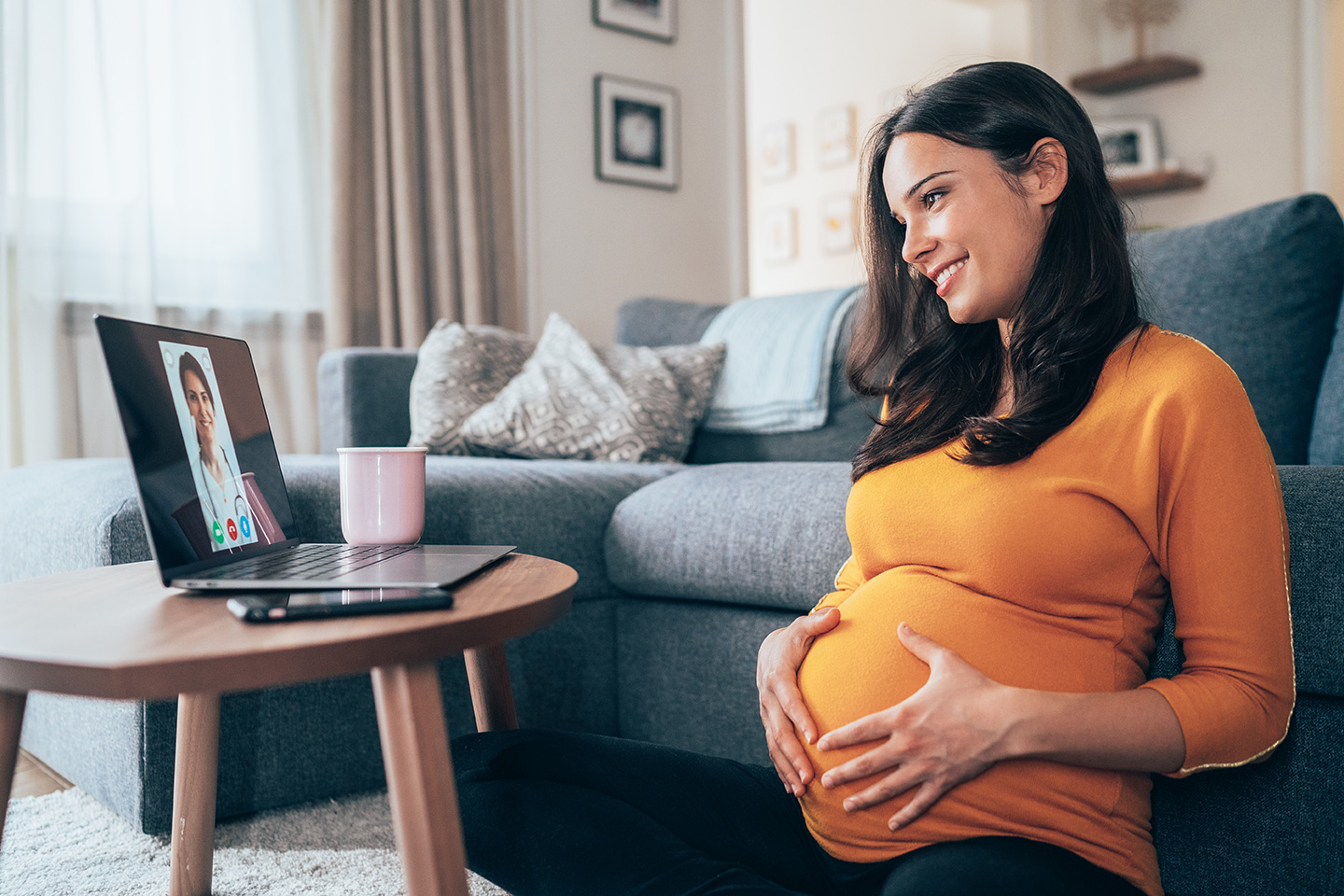 Pregnant woman receiving genetic counseling via a telehealth appointment