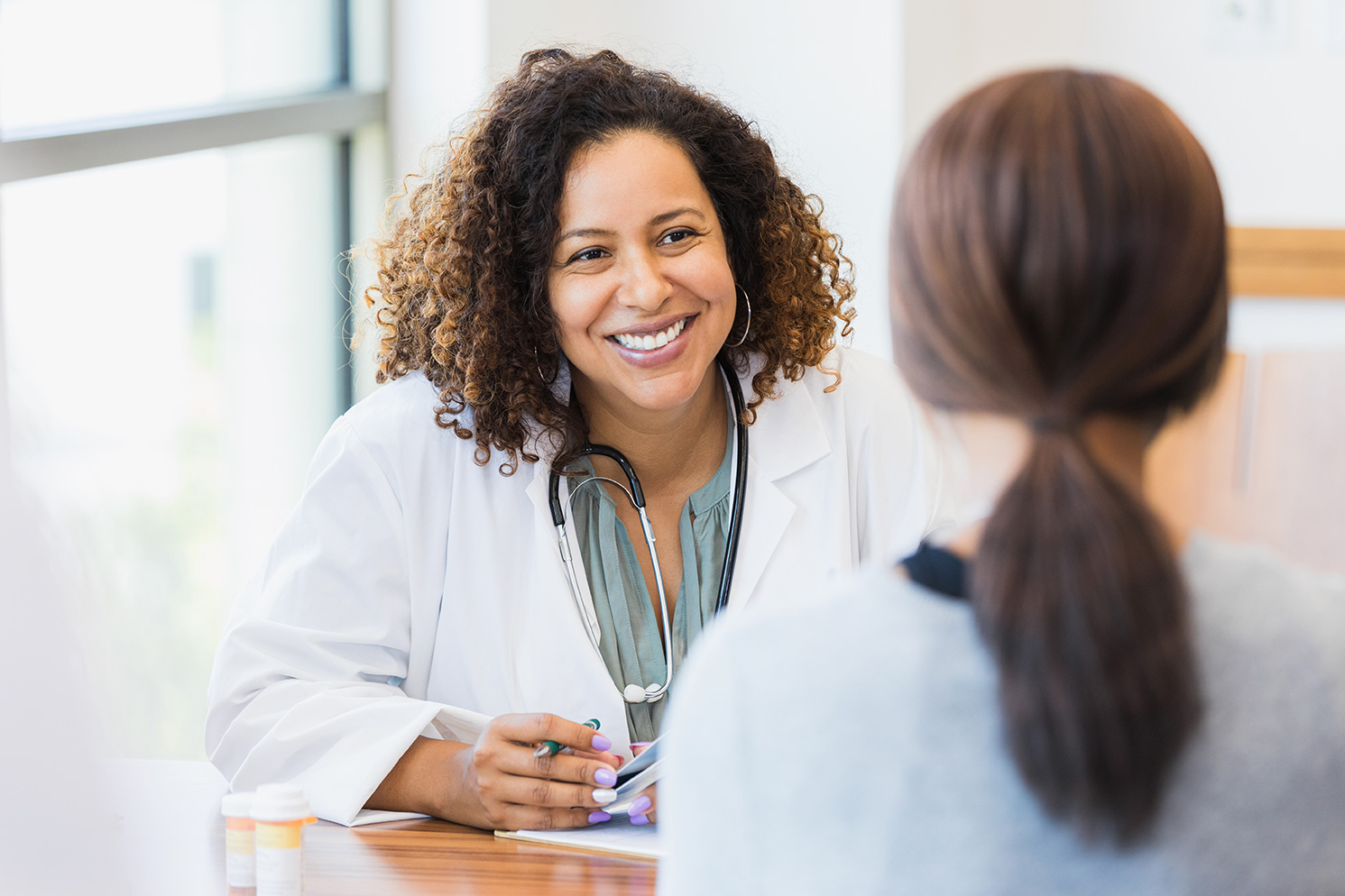 Doctor smiling at patient while discussing pharmacogenomics