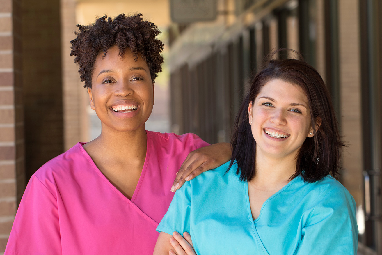 two people in scrubs smiling